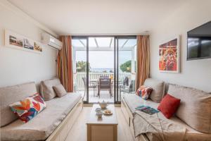 ein Wohnzimmer mit Sofa und Tisch in der Unterkunft Résidence Pierre & Vacances L’Anse De Pramousquier in Le Lavandou