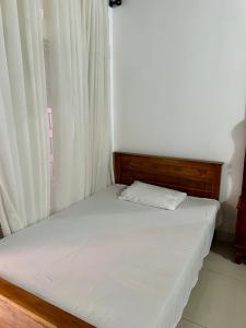 a small bed in a room with a window at Himo Guest Inn in Dehiwala