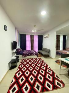 uma sala de estar com um grande tapete vermelho e preto em Vista Alam Roomstay Homestay em Shah Alam