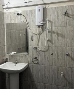 a bathroom with a shower with a sink and a mirror at Himo Guest Inn in Dehiwala