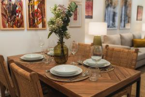 un tavolo in legno con piatti e bicchieri e un vaso con fiori di TuAnfitrion Constitución - Free parking a Granada Altre 40 foto