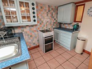 a small kitchen with a sink and a stove at Lion Cottage in Hinderwell