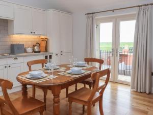 une cuisine avec une table en bois et des chaises ainsi qu'une salle à manger dans l'établissement Waverley Cottage, à Hull