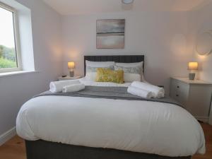 une chambre avec un grand lit blanc avec deux lampes dans l'établissement Waverley Cottage, à Hull