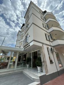 un grande edificio bianco con finestre laterali di Star Hotel & Restaurant a Golem Altre 37 foto