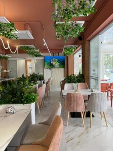 un ristorante con tavoli, sedie e piante di Star Hotel & Restaurant a Golem