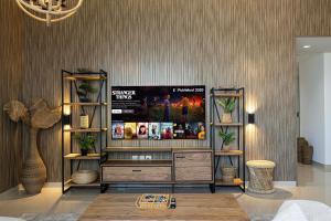 a living room with a flat screen tv on a wall at 2BHK Al Zahia Apartment, Sharjah - Boho Nest in Sharjah +80 photos