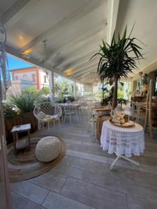 a patio with tables and chairs and a potted plant at Americana Beach House in Rimini