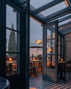 an open patio door with tables and chairs outside at Puris Moedani Boutique Hotel in Tbilisi City