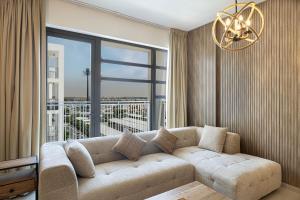 a living room with a couch and a large window at 2BHK Al Zahia Apartment, Sharjah - Boho Nest in Sharjah