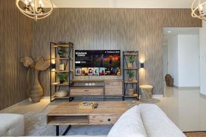 a living room with a tv and a couch at 2BHK Al Zahia Apartment, Sharjah - Boho Nest in Sharjah