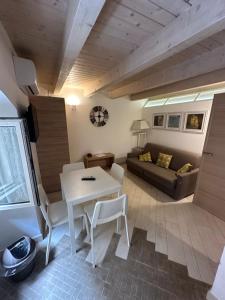 ein Wohnzimmer mit einem Tisch, Stühlen und einem Sofa in der Unterkunft More Apartments il Ferrarese2 in Bari