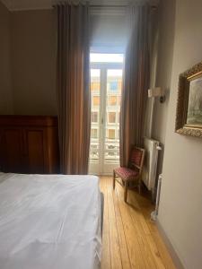 una camera con un letto e una sedia e una finestra di Smartflats - Residence Collector a Bruxelles