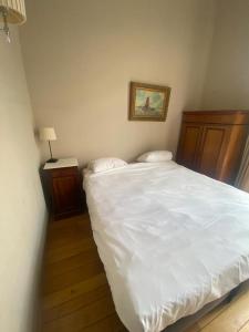 - une chambre avec un grand lit blanc et une lampe dans l'établissement Smartflats - Residence Collector, à Bruxelles