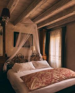 een slaapkamer met een hemelbed en een raam bij Locanda Sandi in Valdobbiadene