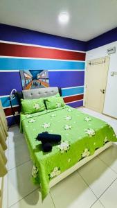 a bedroom with a green bed with flowers on it at Vista Alam Roomstay Homestay in Shah Alam