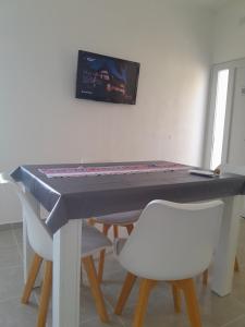 a ping pong table with two chairs and a tv on the wall at La Celestina in Ramallo