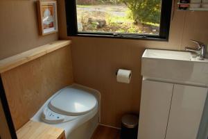 a small bathroom with a toilet and a sink at Tranquility in Owaka