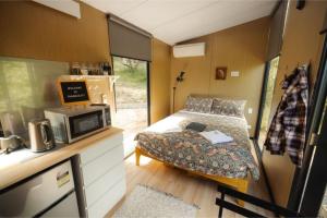 a small bedroom with a bed in a tiny house at Tranquility in Owaka