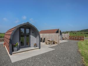 a circular shed with a table and a bench at Parys Pod in Bodewryd