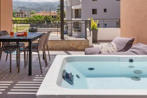 a bath tub sitting on a patio with a table at ARGENO Suites in Lefkada Town