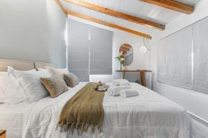 a bedroom with a large white bed with towels on it at ARGENO Suites in Lefkada Town