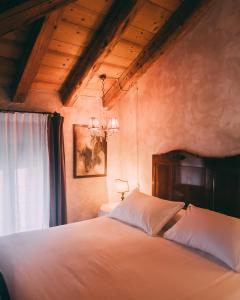 una camera da letto con un grande letto bianco e una finestra di Locanda Sandi a Valdobbiadene