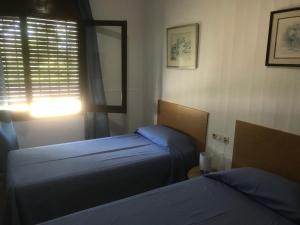 a bedroom with two beds and a window with at PORT LA SARDANA EmpuriaRent in Empuriabrava