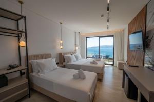 um quarto de hotel com duas camas e uma televisão em Litan Hotel em Sarandë
