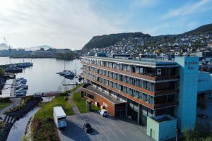 un grande edificio accanto a un corpo idrico di Quality Hotel Ulstein a Ulsteinvik