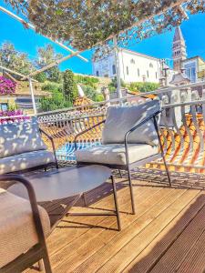 - un balcon avec 2 chaises et un parasol dans l'établissement Seabed Apartma 1, à Piran