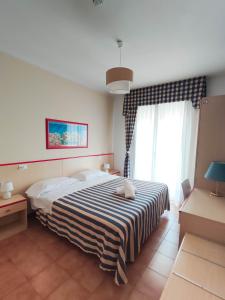una camera da letto con un grande letto con una coperta a righe di Hotel Riviera a Lido di Jesolo