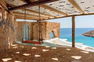 une maison sur la plage avec une balançoire dans l'établissement Calilo, à Manganari