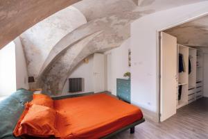 een oranje bed in een kamer met een plafond bij Appartamento Dell'arco in Galatina