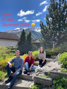 trzy osoby siedzące na schodach ogrodu w obiekcie Haus Seebach w mieście Mallnitz