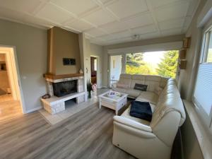 a living room with a couch and a fireplace at Schickes Ferienhaus, freistehend, direkte Waldlage, Terrasse, Kamin, Garten, WLAN in Wienrode