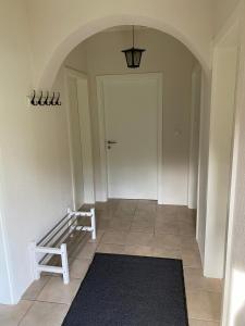 a hallway with a white door and a black rug at Schickes Ferienhaus, freistehend, direkte Waldlage, Terrasse, Kamin, Garten, WLAN in Wienrode