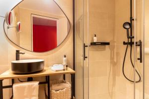 uma casa de banho com um chuveiro, um lavatório e um espelho. em Aiden by Best Western Paris Roissy CDG em Roissy