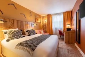 ein Hotelzimmer mit einem großen Bett und einem Schreibtisch in der Unterkunft Aiden by Best Western Paris Roissy CDG in Roissy-en-France
