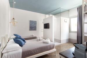 a bedroom with a bed with blue pillows and a mirror at Fico! Apartments by MONHOLIDAY in Monopoli