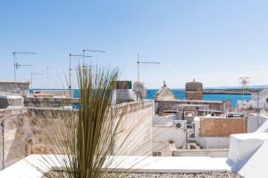 une plante sur un bâtiment avec l'océan en arrière-plan dans l'établissement Fico! Apartments by MONHOLIDAY, à Monopoli