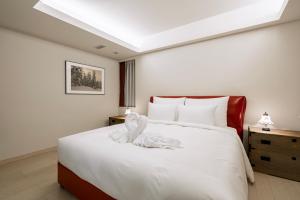 a bedroom with a bed with a white animal on it at Grand Phenix Hakuba by Jade Villa in Hakuba