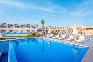 a pool at a resort with chairs and umbrellas at Sunrise Anjum Resort in Marsa Alam City