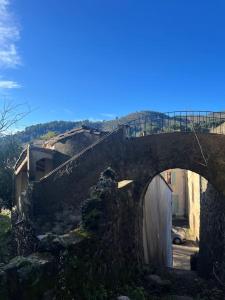 een oude stenen brug met een poort erboven bij Maison cévenole typique et son jardin suspendu in Lasalle