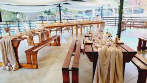 a row of wooden tables with candles on them at Mabalel Lodge in Nelspruit