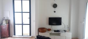 a living room with a tv on a wall at Casa Mascia Pinna in Maracalagonis