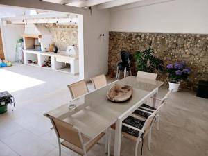 a table and chairs in a room with a stone wall at Casa Mascia Pinna in Maracalagonis