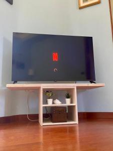 a flat screen tv sitting on a wooden tv stand at MarePorto House in Fiumicino