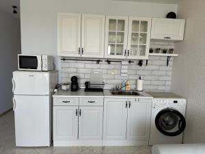 a kitchen with a white refrigerator and a washing machine at Studio E32 Atia Resort Chernomoretz in Chernomorets