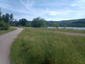 a path in a field next to a body of water at Le couvent des Capucines - La Suite Comedia del Arte in Saint-Vallier